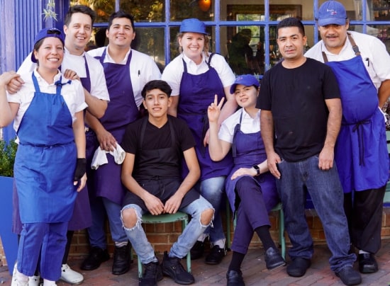 Restaurant staff poses outside the restaurant.